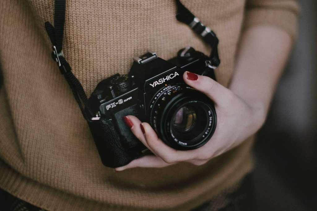 Fotografo con una macchina fotografica analogica fra le mani